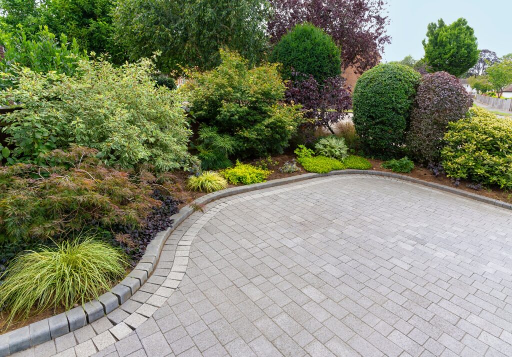 Stylish block paving drive with beautiful garden border with shrubs and flowers - A Robinson Landscaping Services Paths and Driveways